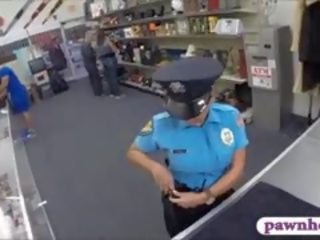 גברת משטרה קצין מזוין על ידי pawnkeeper בפנים ה pawnshop